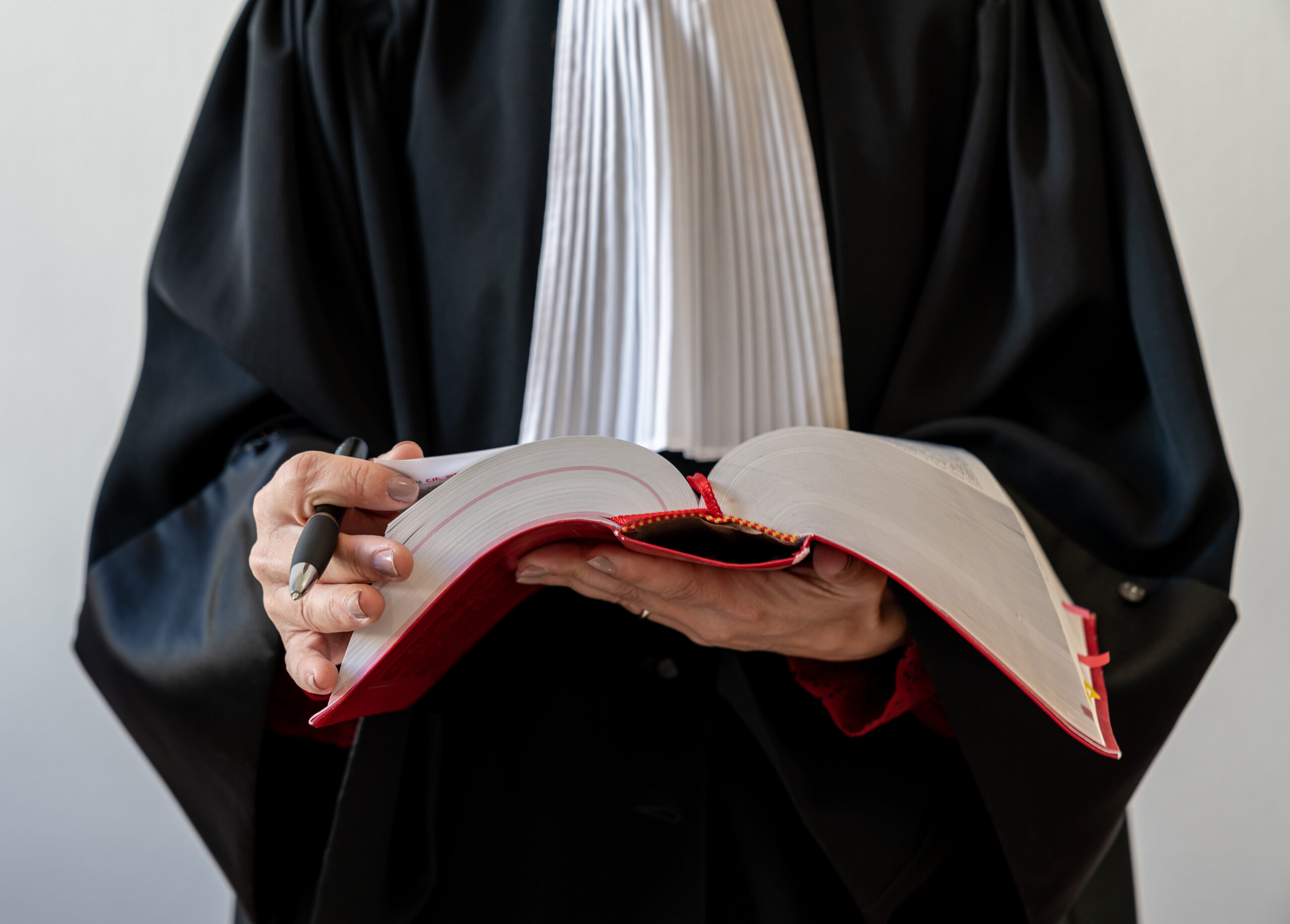Justice,,Lawyer,Holding,And,Reading,Open,Red,Law,Book,-